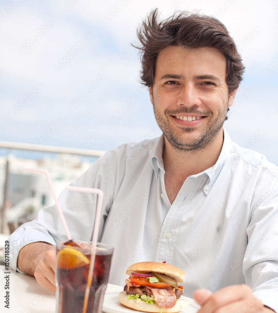 Young man eating a hamburguer