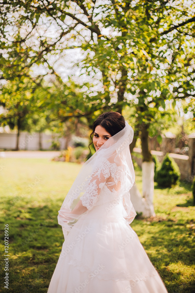 Young bride wearing gorgeous wedding dress, playing with veil.  plays a wedding dress. Dress develops in the wind. Happy bride in a wedding dress is spinning.