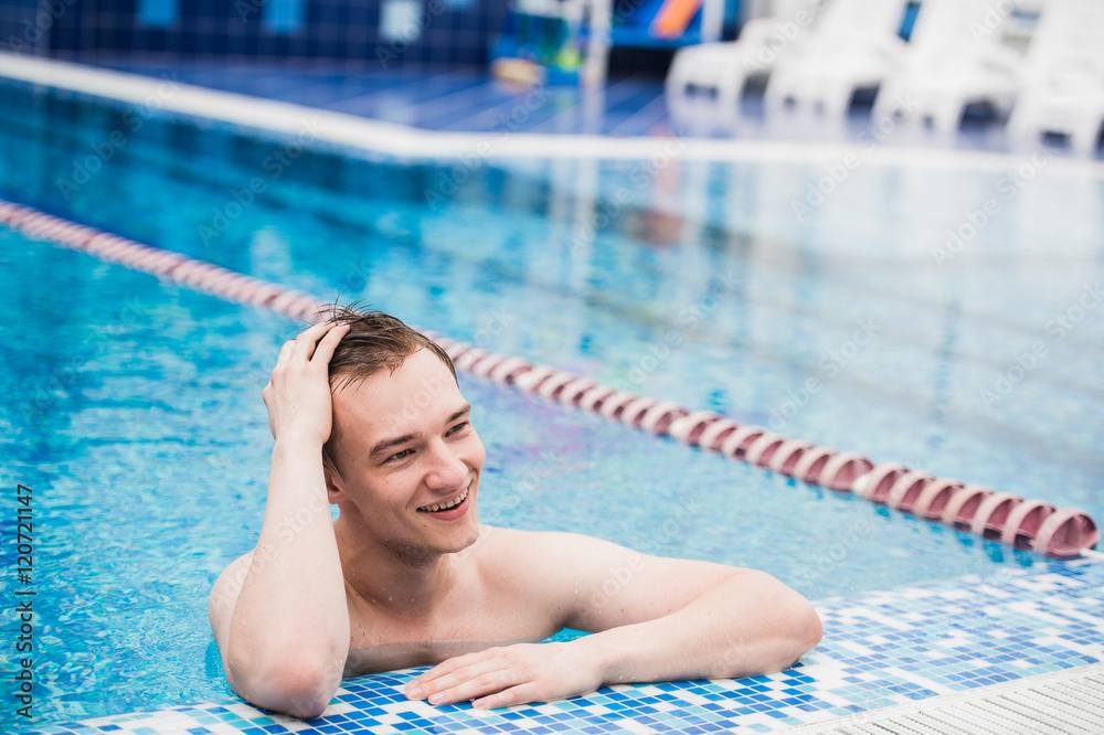 Portrait of young sexy handsome man in swimming pool