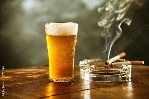 Frothy ice cold beer and cigarette in a pub