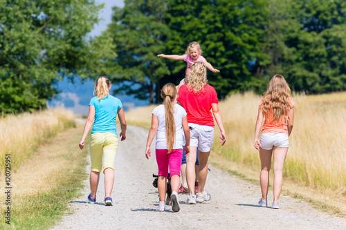 Familie, Mutter, Vater und Kinder beim Spaziergang im Sommer