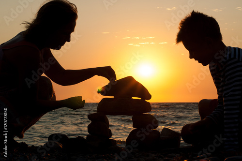 grandmother with her grandson on the beach at sunset