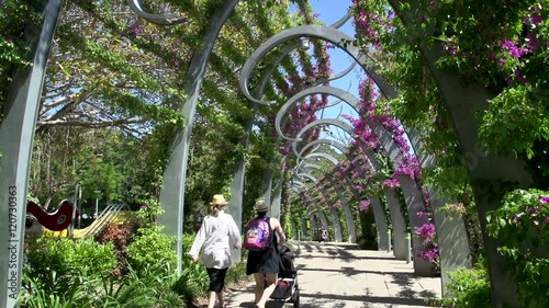 Tilt from promenade to people walking in South Bank Parklands in brisbane 