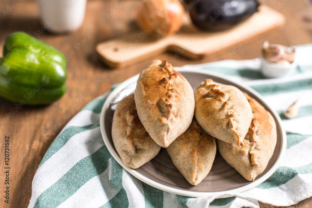 Hot pies with mushrooms on plate, vegetable calzone Hot pies with mushrooms on plate, vegetable calzone