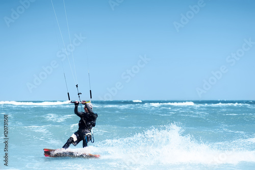 young man kiting in clear blue water