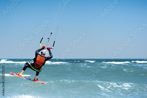 young man kiting in clear blue water