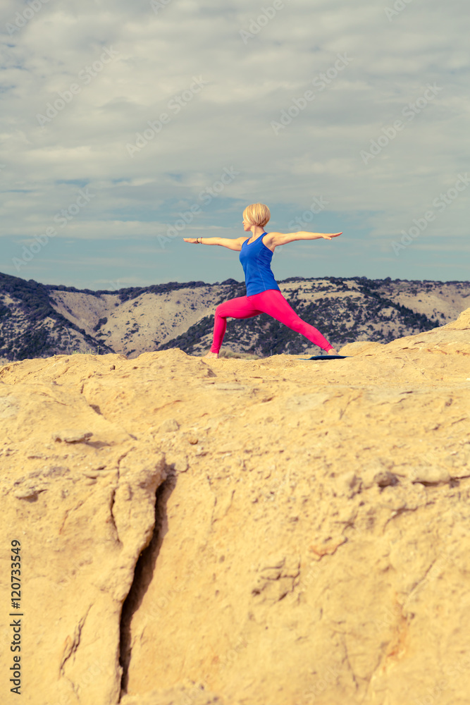 Woman meditating in yoga pose at the sea and mountains