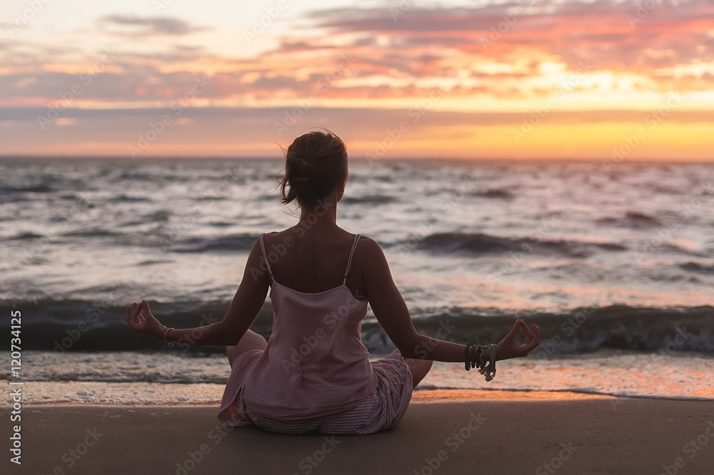 young woman practicing yoga on the ocean sandy beach at sunset young woman practicing yoga on the ocean sandy beach at sunset