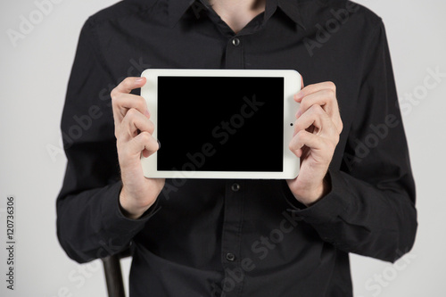 Business man holding and shows touch screen tablet pc with blank screen