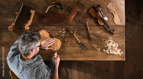 Foto Top view. Artisan luthier working on the creation of a violin