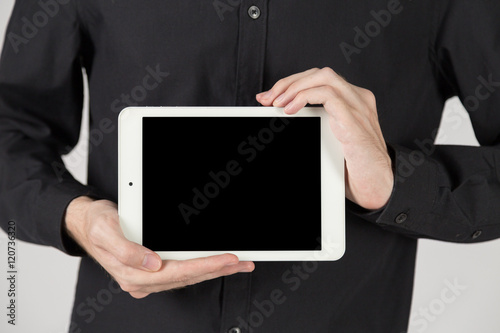 Business man holding and shows touch screen tablet pc with blank screen