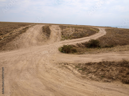 Пыльная грунтовая дорога ведет на вершину холма в Крыму