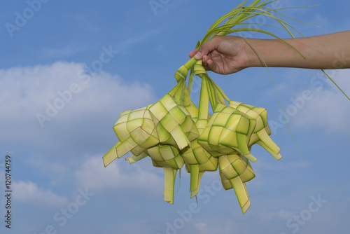 Wallpaper Mural A hand holding Ketupat - Malay cuisine made from glutinous rice packed inside a diamond shaped container of wooven palm leaf. Torontodigital.ca