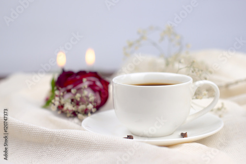 coffee in bed. cup of coffee with spices cloves on a white blanket