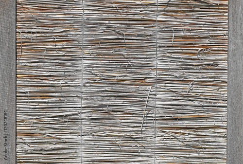A fence made of reeds and wooden planks texture