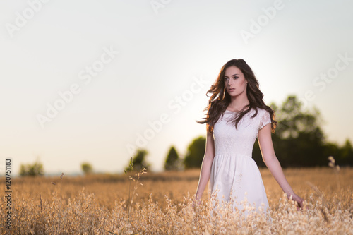 Woman posing in a cornfield at sunset