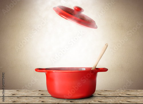 Big red pot for soup with spoon and fork