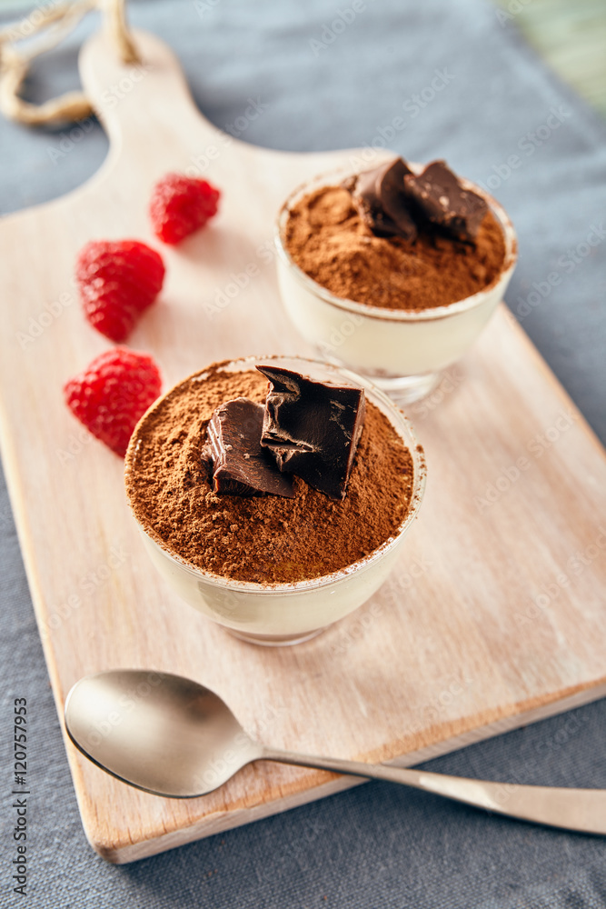 Panna cotta with chocolate on a white chopping board, bright colors Panna cotta with chocolate on a white chopping board, bright colors