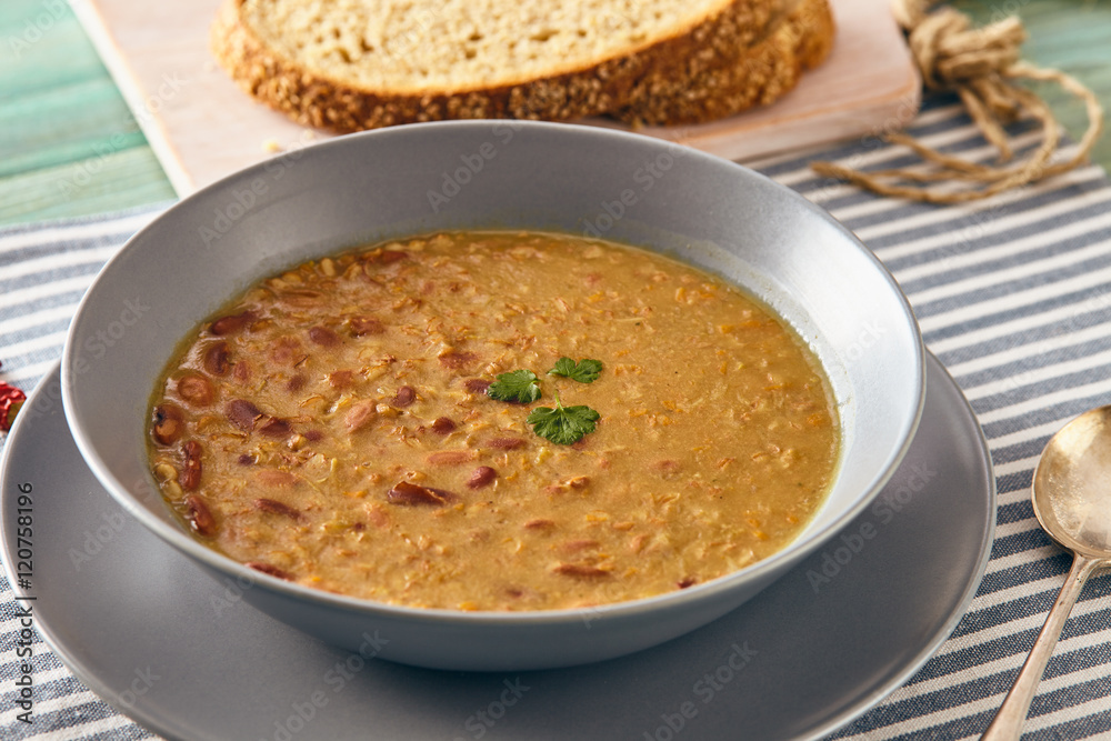 bean and spelt soup on a wooden table, bright colors bean and spelt soup on a wooden table, bright colors