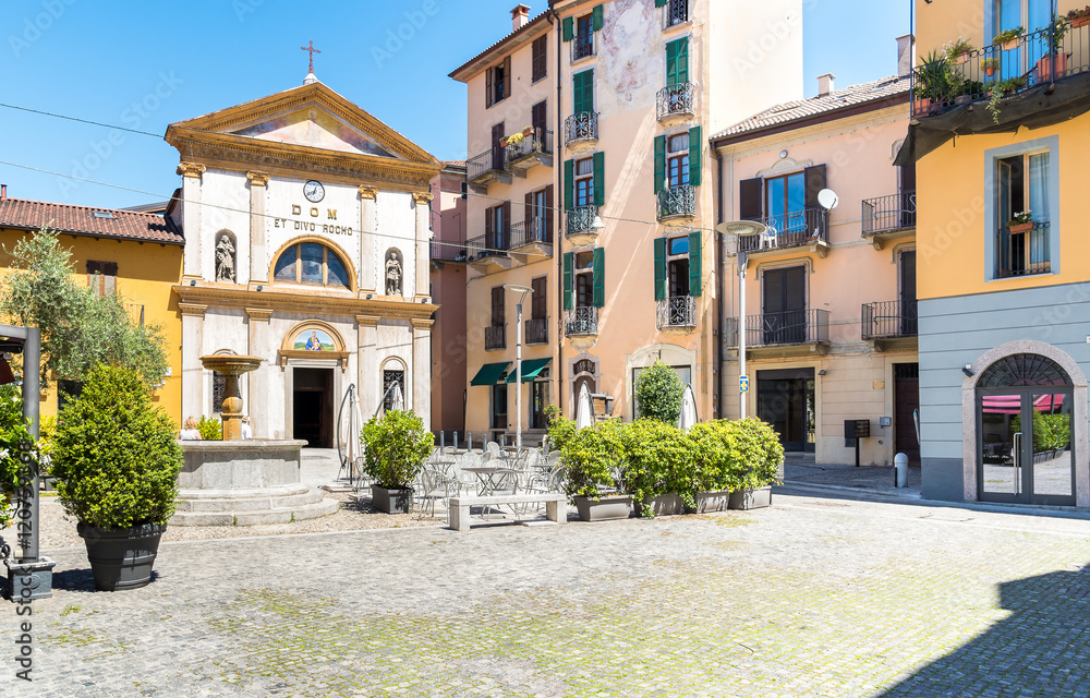Piazza San Rocco with restaurant, fountain and church in the historic center of Verbania Intra, Italy