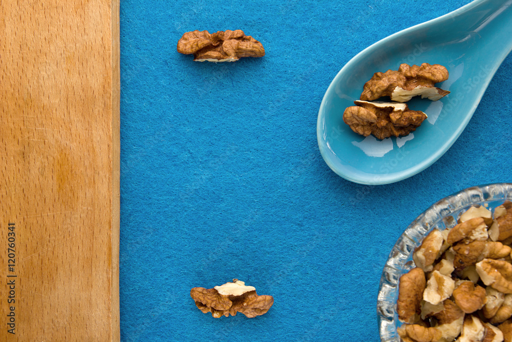 Walnuts. Top view of wooden Board and blue background. For kitchen and menu Walnuts. Top view of wooden Board and blue background. For kitchen and menu