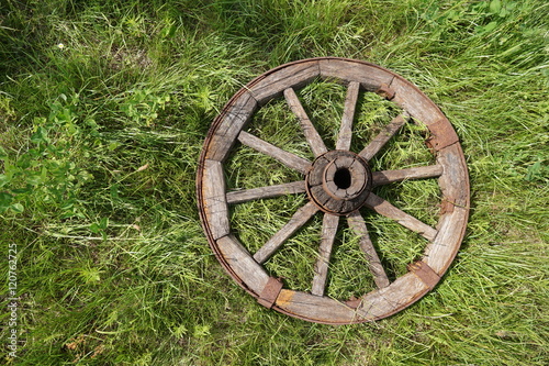 wooden wheel on a background of green grass