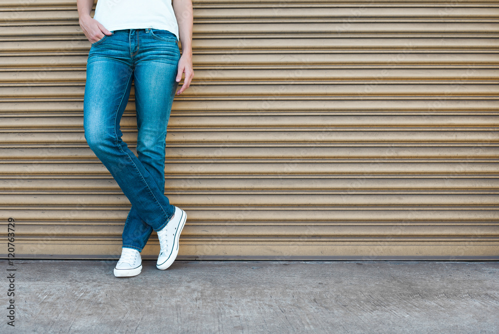 Girl wearing blue jeans and sneakers. Stock Photo | Adobe Stock
