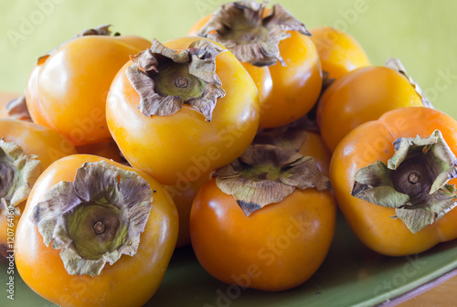 Bild auf Leinwand Golden persimmons on a plate
