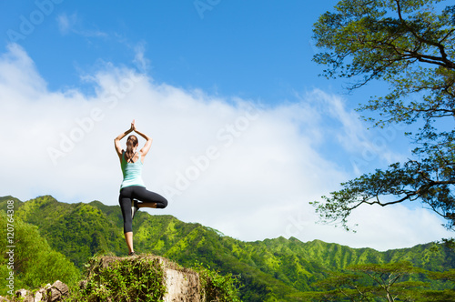 Woman doing yoga exercise in a beautiful nature setting. 