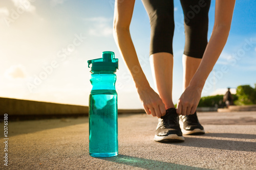 Drinking water and sports concept.  Bottle of water next to runner. 
