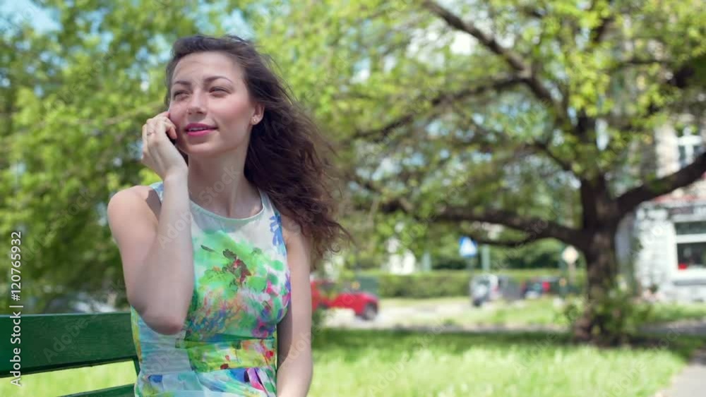 Pretty girl chatting on cellphone in the park and smiling
Pretty girl chatting on cellphone in the park and smiling