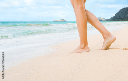 Woman walking on beautiful white sand beach. (location Hawaii) 