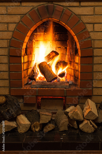 wooden logs and fire in fireplace