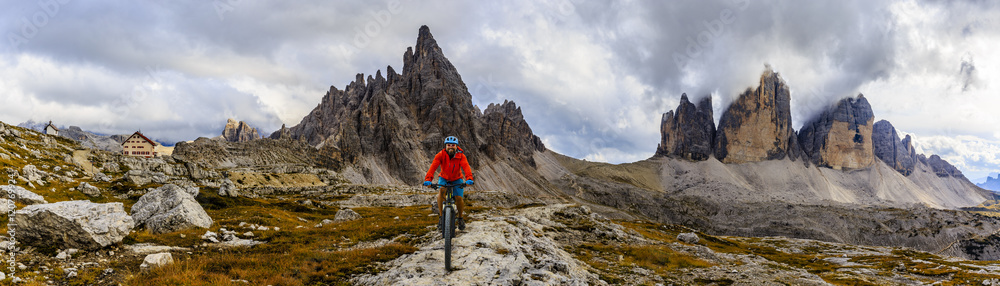 Mountain biking in the Dolomites. Amazing panorama of Tre Cime di Lavaredo in background.