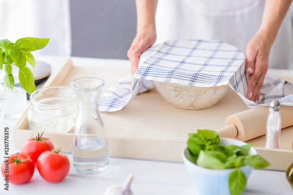 Woman covering yeast dough with towel. Woman covering yeast dough with towel.
