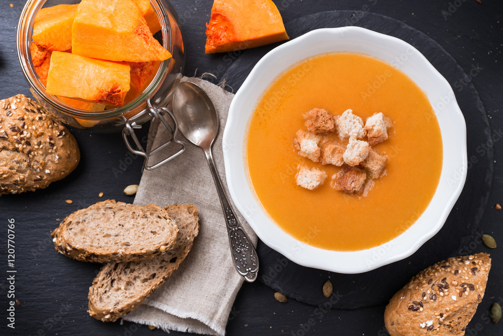 Pumpkin soup in a white bowl on table Pumpkin soup in a white bowl on table