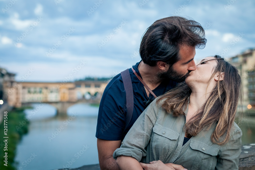 Couple kissing at sunset in front of Ponte Vecchio Florence Couple kissing at sunset in front of Ponte Vecchio Florence