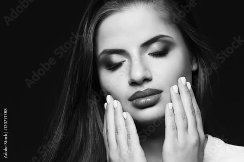 Portrait of beautiful young woman on dark background. Black and white