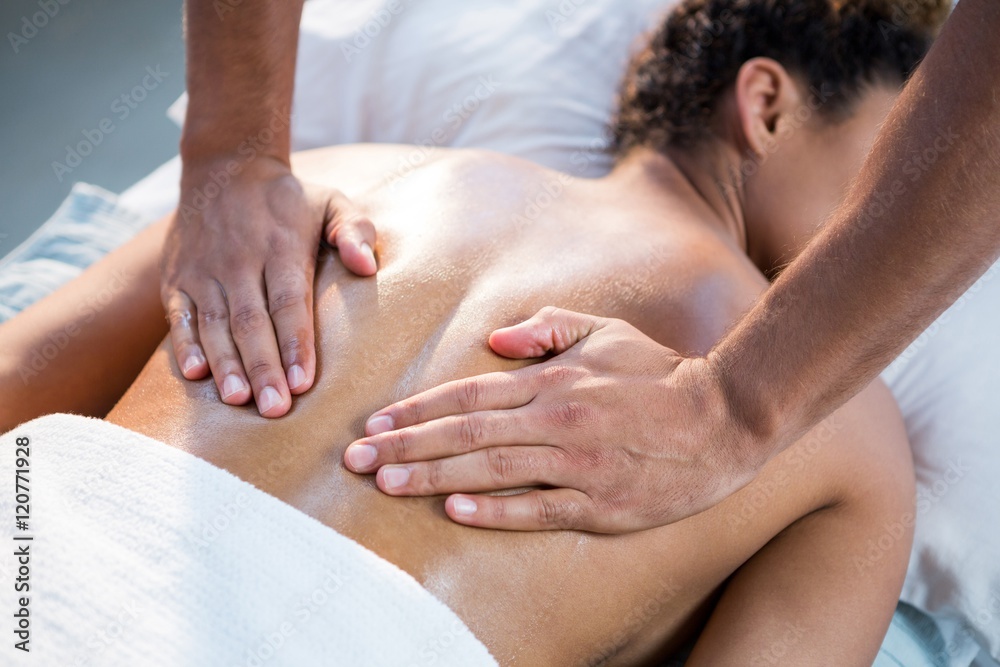 Woman receiving back massage from physiotherapist Woman receiving back massage from physiotherapist