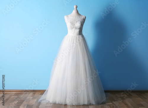 Beautiful wedding dress on floor beside wall