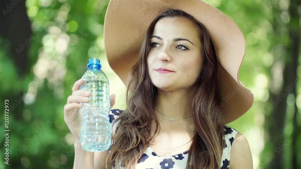 Beautiful girl drinking water in the forest and looking happy
Beautiful girl drinking water in the forest and looking happy
