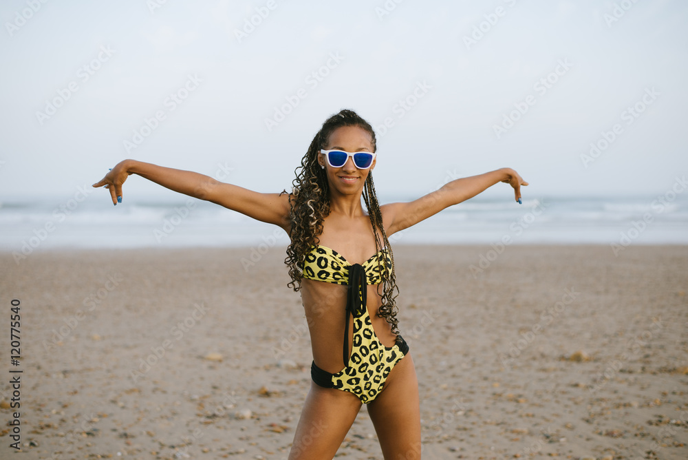 Graceful stylish brazilian woman in fashion bikini dancing and enjoying  vacation at the beach. Black female model with dreadlocks and trikini  exotic swimwear. Photos