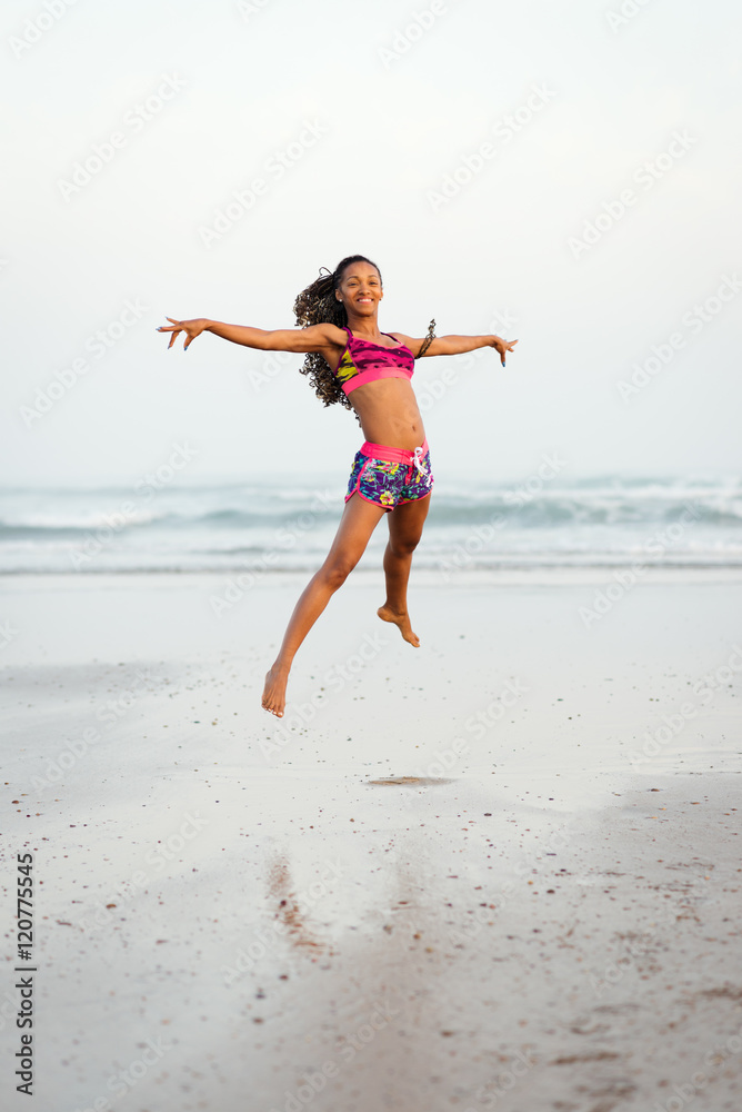 Graceful happy black woman dancing and jumping at the beach. Sporty female having fun and enjoying ocean freedom. Graceful happy black woman dancing and jumping at the beach. Sporty female having fun and enjoying ocean freedom.
