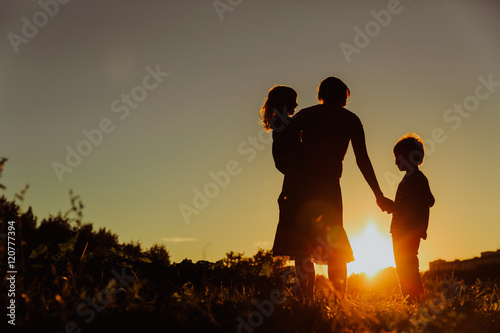 mother and two kids walking on sunset