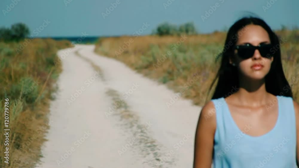 Slim girl goes by sandy road to the beach Slim girl goes by sandy road to the beach
