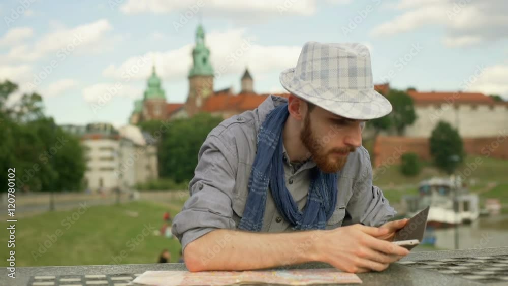 Tourist looking worried while reading map and checking smartphone
Tourist looking worried while reading map and checking smartphone