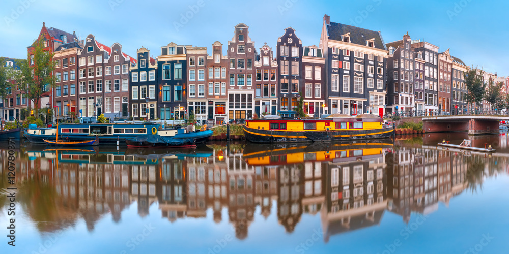 Fototapeta premium Panorama of Amsterdam canal Singel with typical dutch houses and houseboats during morning blue hour, Holland, Netherlands.