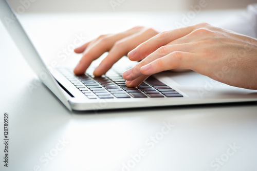 Close-up of hands of business man typing on a laptop.