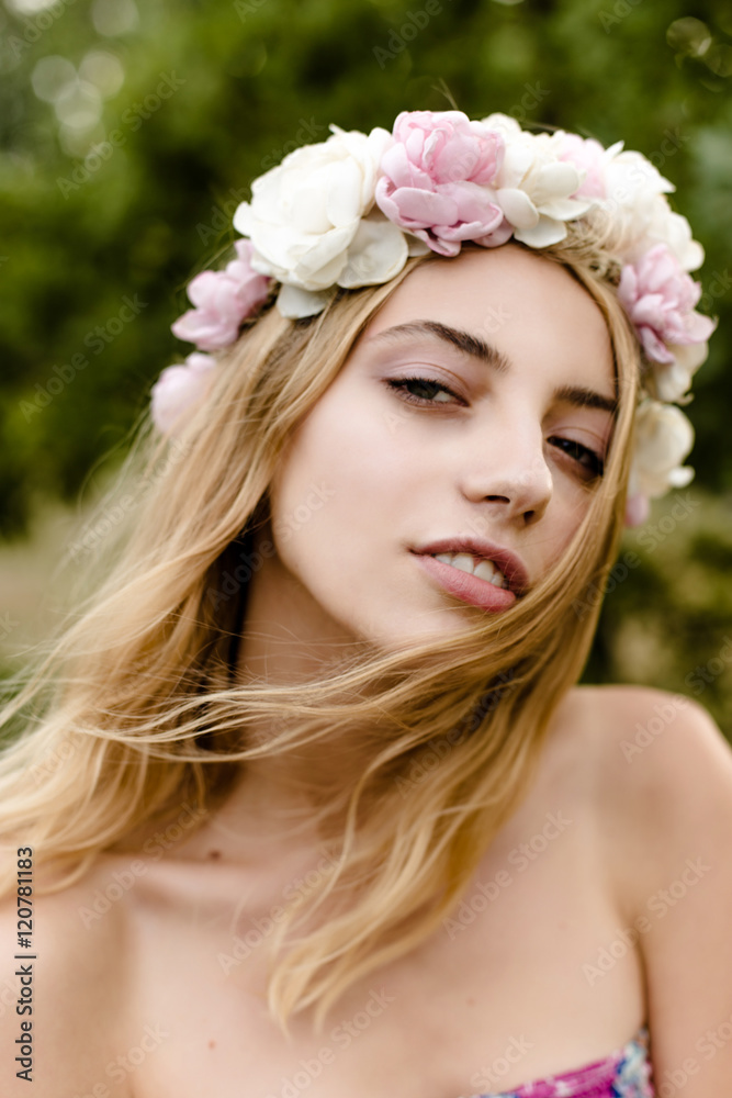 Young girl in flower wreath walking in meadow Young girl in flower wreath walking in meadow