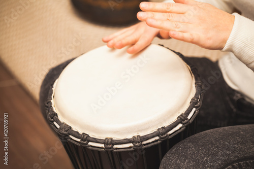 Drummer plays on small African drum
